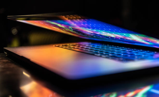 istock A laptop half closed in the dark with colourful glow. 1488410864