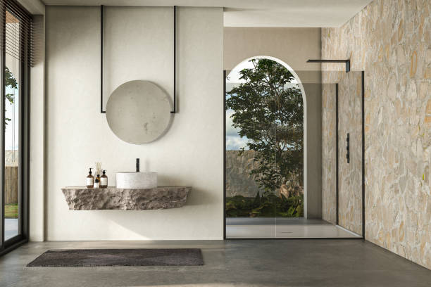 istock Modern bathroom featuring a natural stone countertop with an integrated sink, a round mirror, a shower cabin, a round bathtub, and a sleek concrete floor. The natural light, back yard. 3d rendering 1488412441