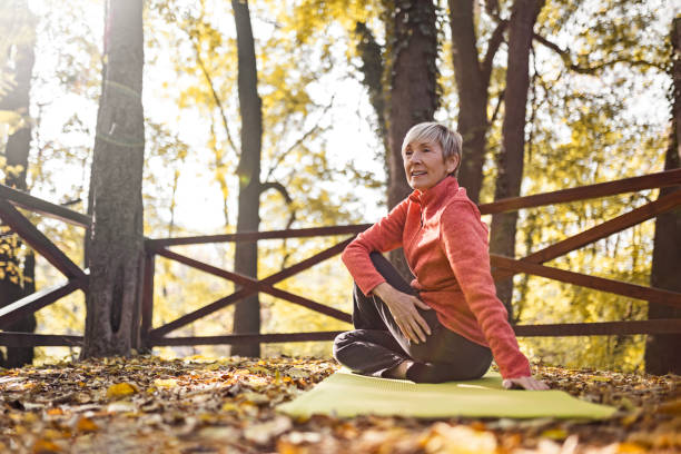 starszy kobieta praktykowania jogi - healthy lifestyle yoga vitality flexibility zdjęcia i obrazy z banku zdjęć