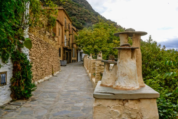 street of a town in the Alpujarra of Granada with chimneys decorating the viewpoint of the street stock photo