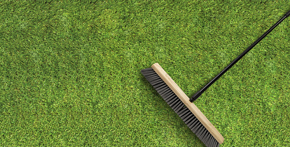 Top view green lawn grass with a cleaning broom