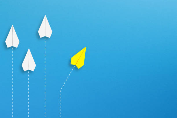 istock Yellow paper plane coming out from the advancing white paper planes 1488417006