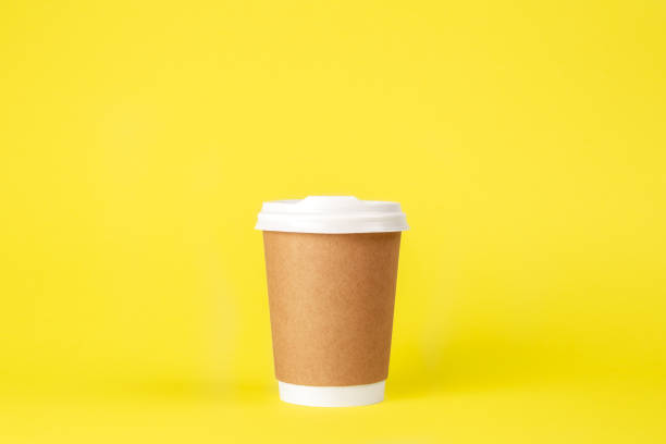 istock Disposable paper cup on a yellow background isolated. 1488417669