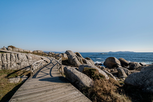 Zigzag wooden walkway in the rocky coastline of San Vicente Do Mar, Pontevedra, Spain