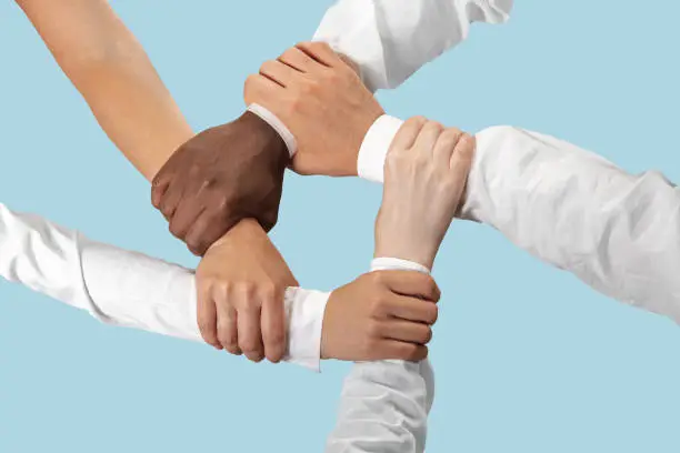To be a good team. Teamwork and communications. Male and female hands holding isolated on blue studio background. Concept of help, partnership, friendship, relation, business, togetherness.