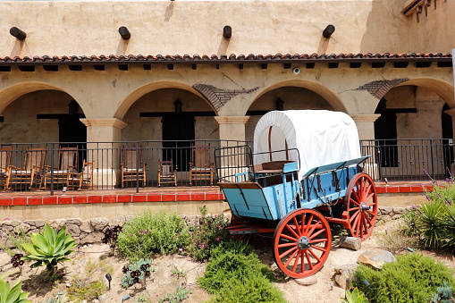 San Diego, California, USA - April 13, 2023: A covered wagon in front of the hacienda porch, in Old Town San Diego.