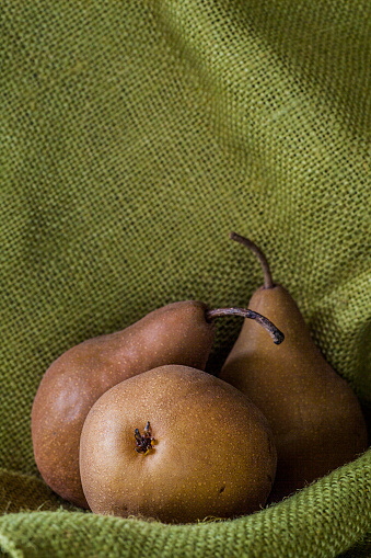 Brown pears in a still life with a rustic background.