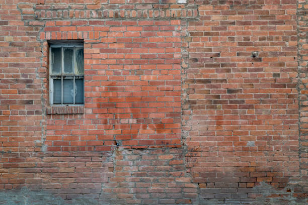istock urban texture and background - grunge brick wall with a small, neglected window 1488420195