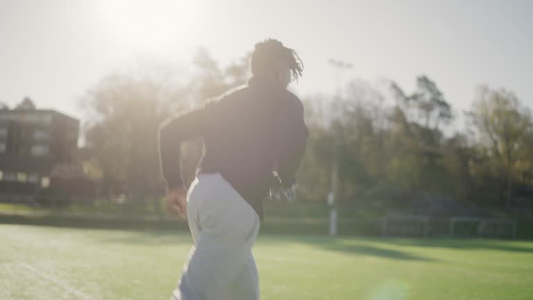 Man practicing soccer by himself, having fun running around on the field