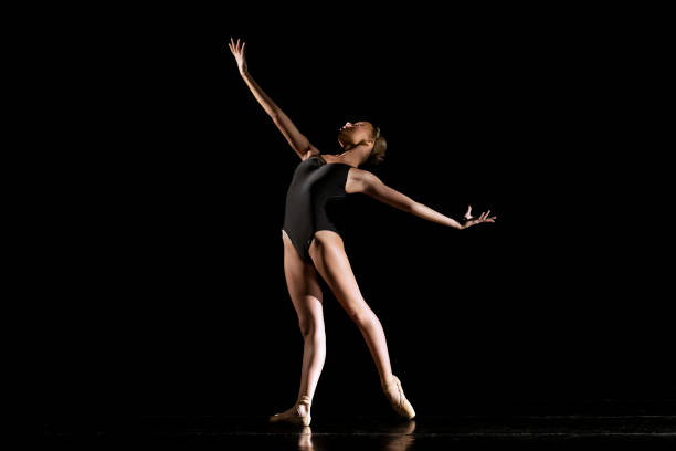 istock Young girl dancing Neo Classic Ballet on dark stage 1488423555