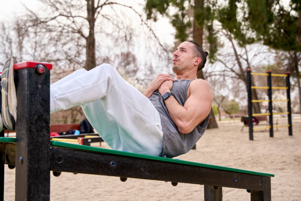 istock Young man doing sit-ups during workout in a calisthenics street workout park 1488425236