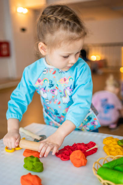 istock A little girl playing with plasticine. Sensory development and experiences, themed activities with children, fine motor skills development 1488426346