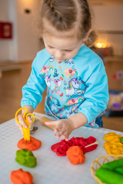 istock A little girl playing with plasticine. Sensory development and experiences, themed activities with children, fine motor skills development 1488426401