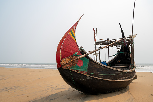 Traditional Bangladeshi Moon Boat on the beach at Cox's Bazar in Bangladesh and used for sea fishing in the Bay of Bengal by Bengali fishermen