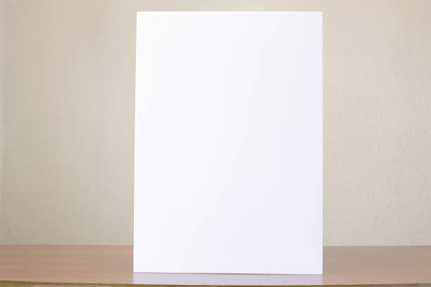 istock A vertically raised blank sheet isolated on a wooden table 1488427642