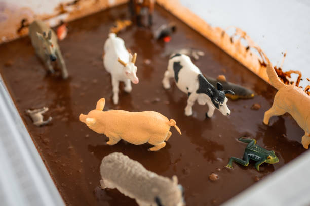 Homemade chocolate sensory mud with farm animal models. Sensory development and experiences, themed activities with children, fine motor skills development