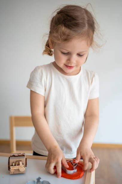 A little girl playing with plasticine. Sensory development and experiences, themed activities with children, fine motor skills development