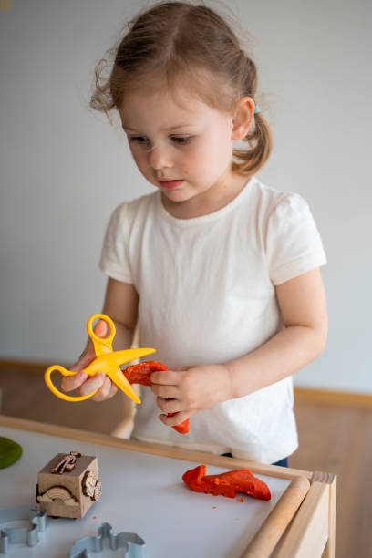 A little girl playing with plasticine. Sensory development and experiences, themed activities with children, fine motor skills development