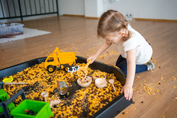istock Little girl playing with sensory flakes in sandbox for playing. Sensory development and experiences, themed activities with children, fine motor skills development 1488427947