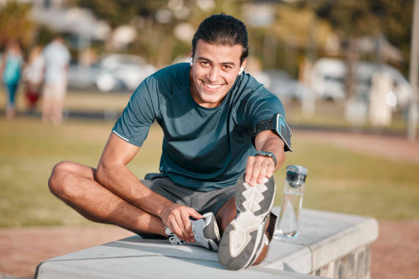 fitness, ritratto e uomo che fa un esercizio di stretching prima di correre o allenarsi per una maratona in un parco. sport, salute e atleta maschio che si riscaldano le gambe prima di un allenamento cardio all'aperto sul campo. - endurance sport foto e immagini stock