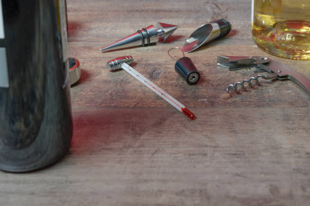 istock Bottled wine set from accessories. Additional stoppers, means for opening, a corkscrew and thermometer. On the texture table. Close-up. 1488429837