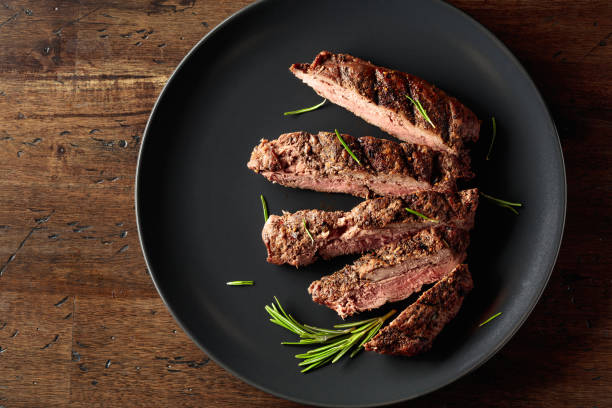 istock Grilled beef steak with rosemary on a black plate. 1488430291
