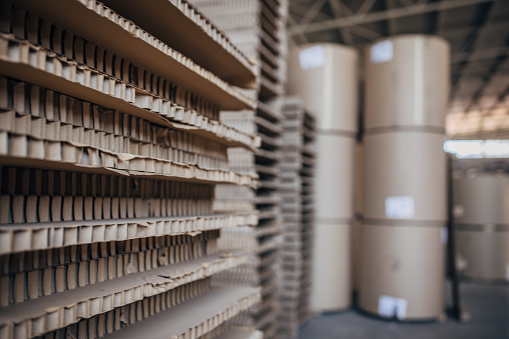 Distribution cardboard factory warehouse with cardboard stacks.