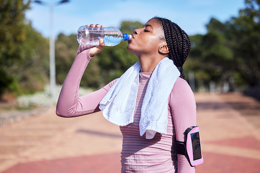 Fitness, black woman and drinking water for hydration, training and exercise for wellness, healthy lifestyle and workout. African female athlete, lady and runner with bottle, aqua and liquid for rest