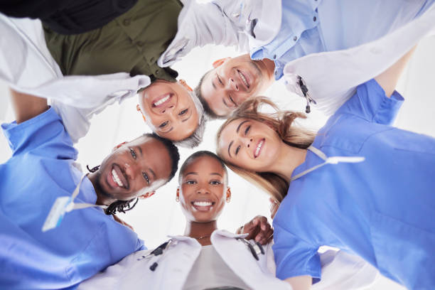 istock Happy teamwork, diversity and doctors in huddle of support, help or medical collaboration. Portrait group of healthcare workers in circle with heads together, smile face and happy hospital management 1488432020