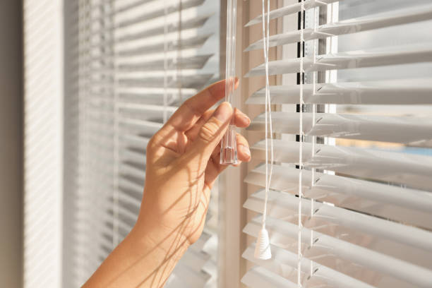 istock Woman opening horizontal blinds on window indoors, closeup 1488432928