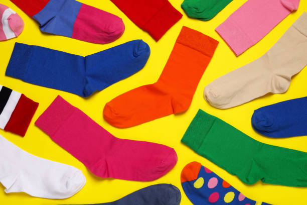 istock Different colorful socks on yellow background, flat lay 1488432980
