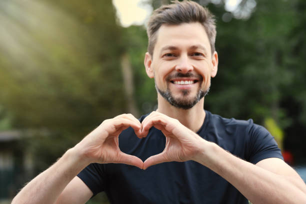istock Happy man making heart with hands outdoors 1488438471
