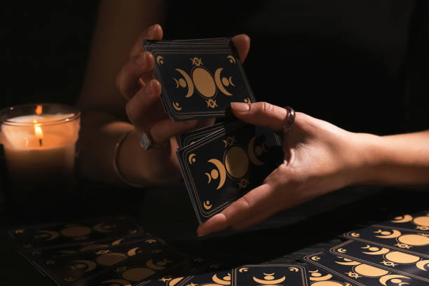 istock Soothsayer shuffling tarot cards at table in darkness. Fortune telling 1488438540