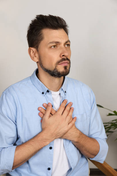istock Man with clasped hands praying in room at home 1488438565
