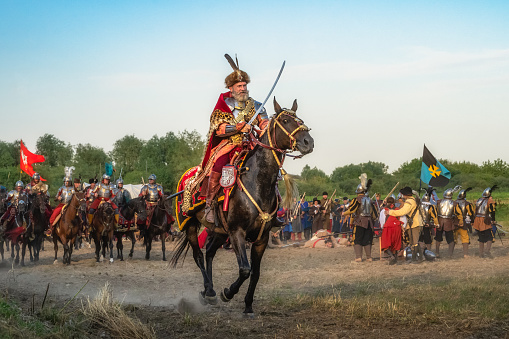 Gniew, Poland, Aug 2020 Castellan riding on a horse with sword out, leading his hussars, Polish heavy cavalry, historical reenactment, Battle of Gniew