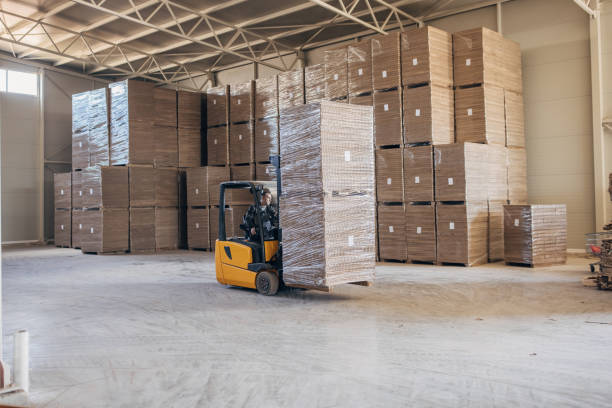 istock Man driving cardboard stacks on forklift 1488441460