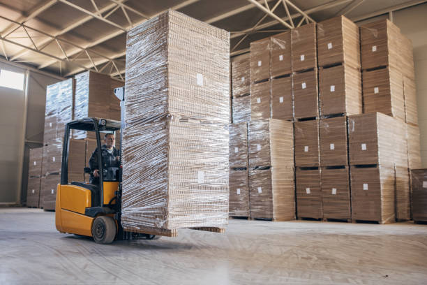istock Man driving cardboard stacks on forklift 1488441581