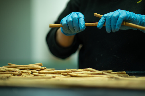 A woman employee preparing crackers in a bakery on a tray.