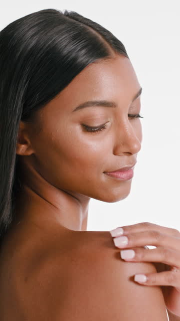 Body, beauty and closeup for skincare of a woman in studio with hand on skin. Indian female model person with manicure or touching shoulder for self care, dermatology and glow or shine cosmetics