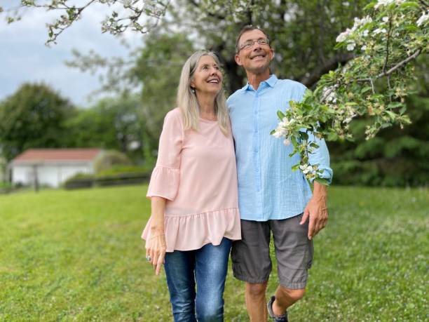 istock Happy senior couple walking under spring  apple tree blossoms 1488447214