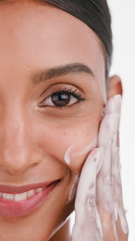 Happy woman, face wash and hands in skincare hygiene or product cosmetics against a white studio background. Closeup portrait of female smiling in beauty cosmetic foam, washing or facial treatment