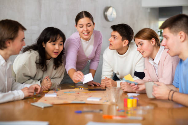 istock Young guys and girls playing board game together 1488451189