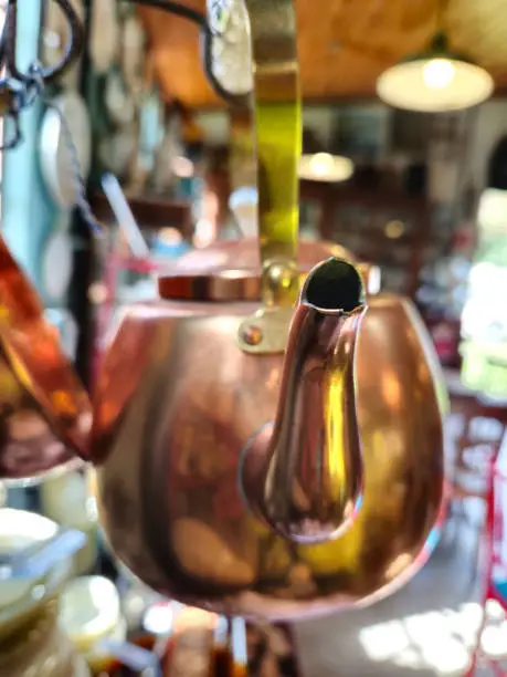 antique copper kettle hanging inside an antique shop