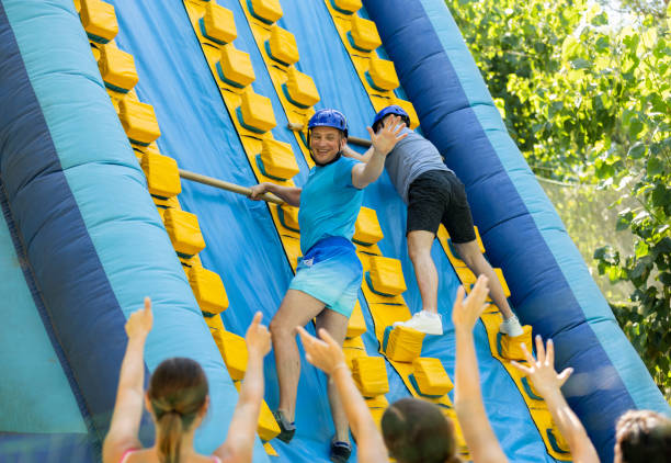 istock Happy active man climbing on inflatable castle with wooden sticks 1488452284