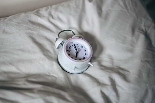 Pillow alarm clock. The concept of sleep problems, insomnia, circadian rhythm.