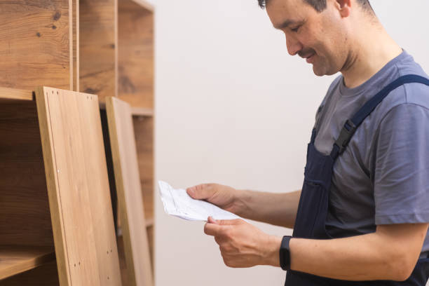 istock Furniture shipping and fixing focused handyman reading instruction to rack assembling 1488455045
