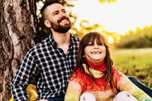 istock Father and elementary age daughter laughing together enjoying time outside in nature in fall 1488455332