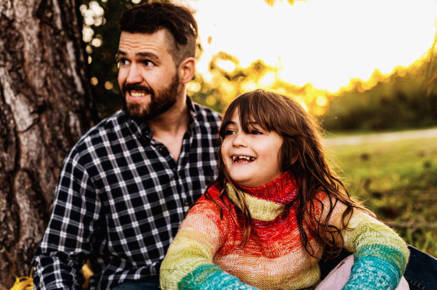 istock Father and elementary age daughter laughing together enjoying time outside in nature in fall 1488455936