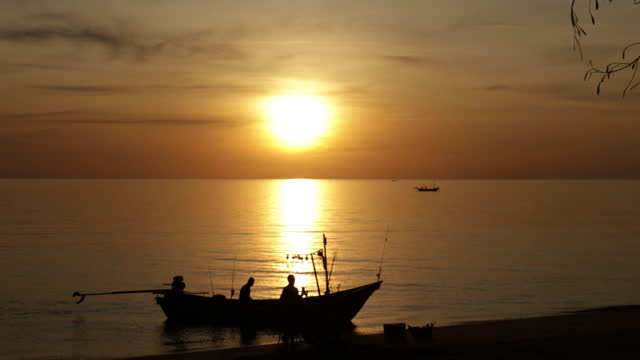 A small fishing boat in the middle of the sea at sunset in Pattani Thailand.