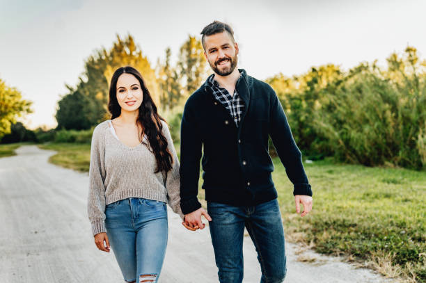 istock Beautiful happy affectionate couple hold hands and walk together outdoors at dusk in the fall 1488456492